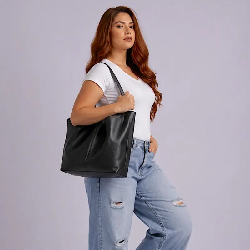 Mulher usando a bolsa shopper em couro  preto na versão aberta