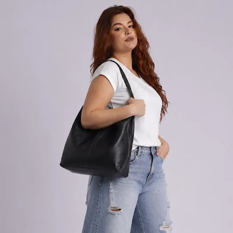 Mulher usando a bolsa shopper em couro  preta