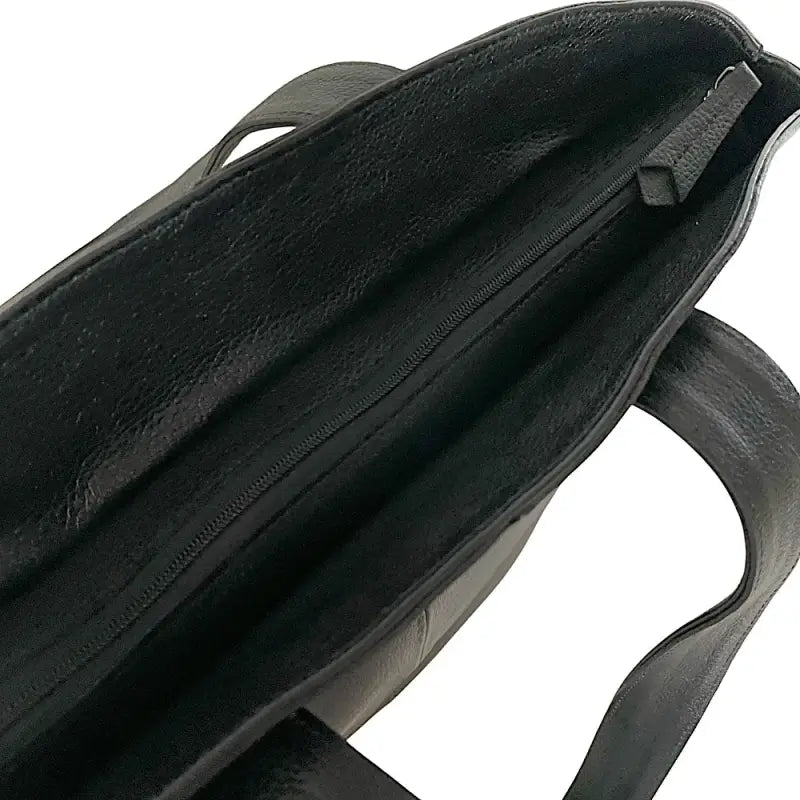 Detalhe aproximado do zíper com puxador em couro legítimo preto.