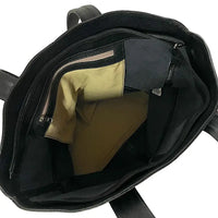 Interior da bolsa shopper preta sem forro, exibindo o bolso suspenso com zíper para celular e documentos.