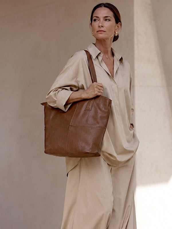 Mulher com maxi calça e camisa bege com bolsa shopper em couro legitimo caramelo