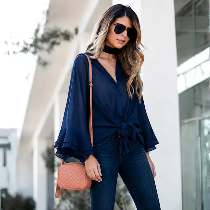 Mulher com look azul marinho usando a bolsa em couro legitimo na cor pêssego no ombro