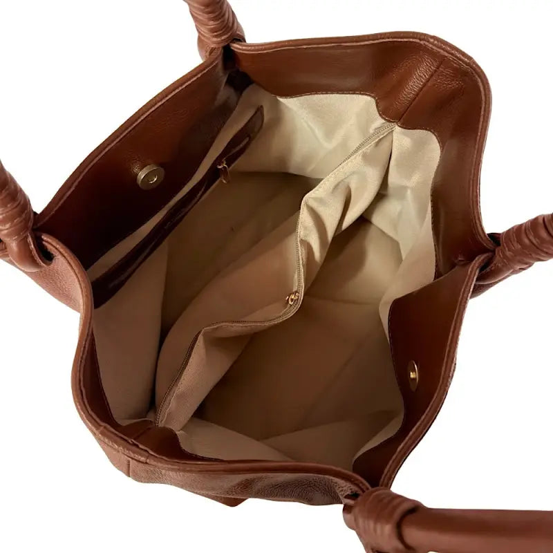 Vista interna da bolsa tote forrada, exibindo a grande divisória central com zíper e os três compartimentos organizadores.