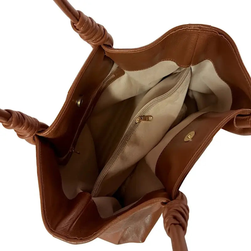 Vista interna da bolsa tote forrada, exibindo a grande divisória central com zíper e os três compartimentos organizadores.