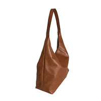 Vista lateral da bolsa estilo sacola caramelo mostrando a profundidade de 12cm e o caimento maleável do couro.
