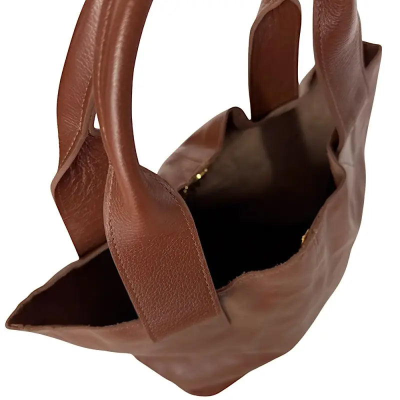 Interior da bolsa shopper marrom moka sem forro, exibindo a carteira com zíper acoplada à corrente dourada.
