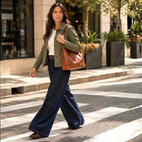 Mulher usando a bolsa hobo grande caramelo embaixo do braço, luxo e originalidade.