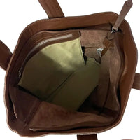 Interior da bolsa shopper sem forro, destacando o bolso suspenso com zíper para celular e chaves.