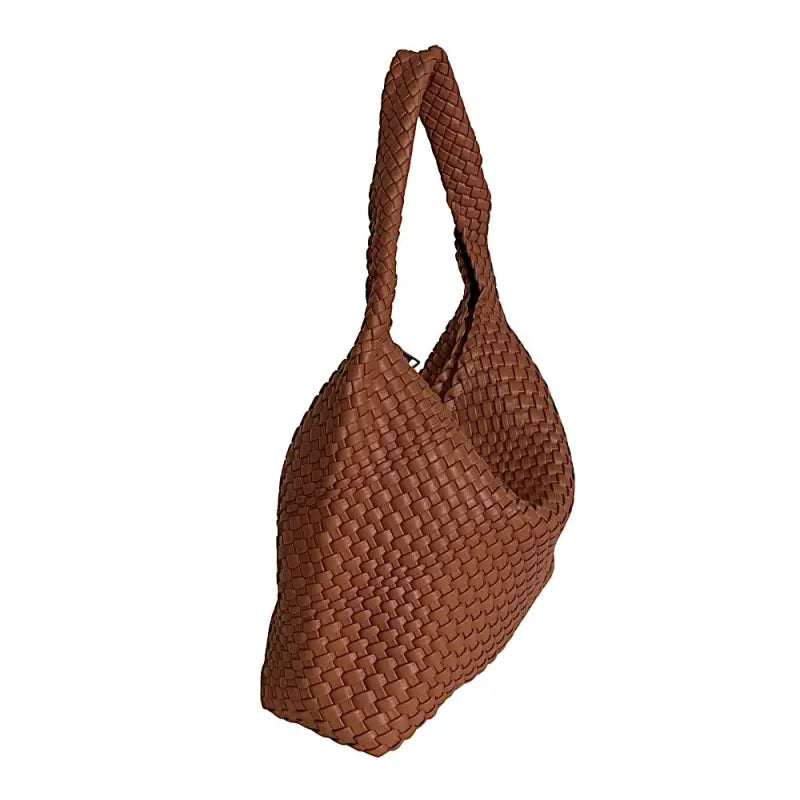 Vista lateral da bolsa hobo caramelo destacando a profundidade e a maciez do couro vegano.