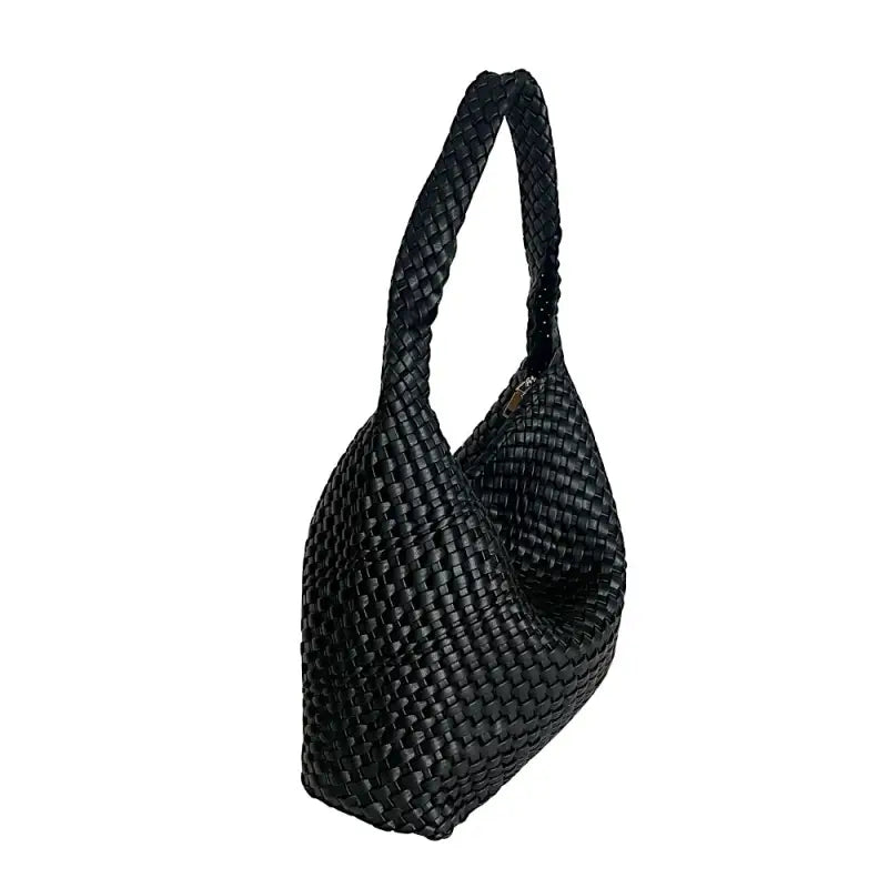 Vista lateral da bolsa hobo preta destacando a profundidade de 13cm e o caimento do tressê.