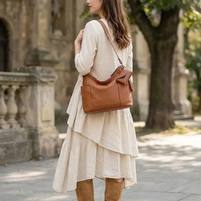 Mulher usando bolsa hobo em couro legitimo com vestido e botas
