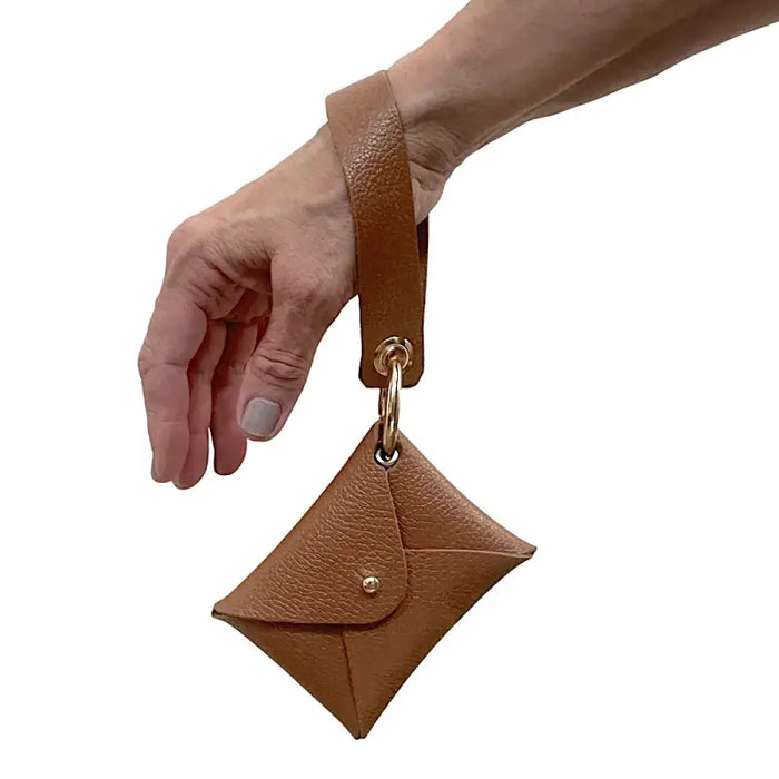 Carteira de pulso caramelo com ferragem dourada, vestida no pulso