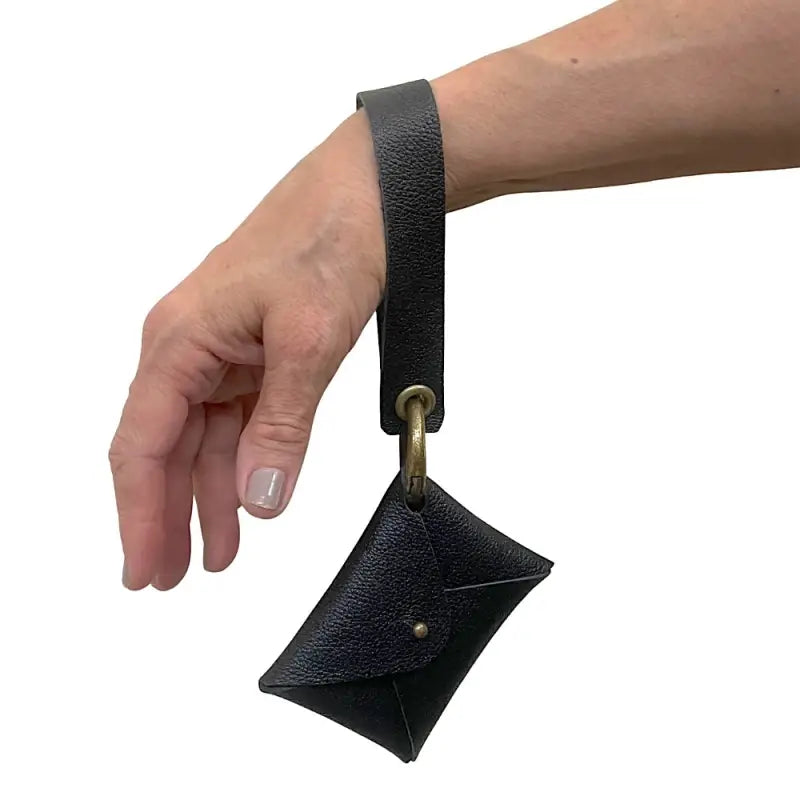 Carteira de pulso em couro preto e ferragem ouro velho colocada no pulso