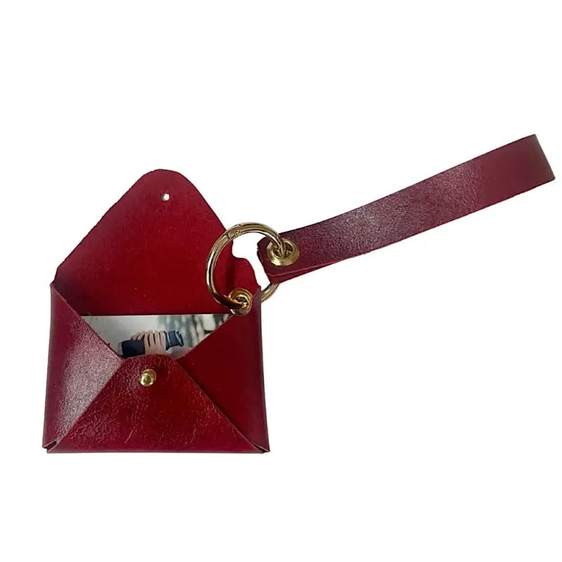 Carteira de pulso vermelha couro liso com pátina natural ferragem dourada. Vista dela aberta